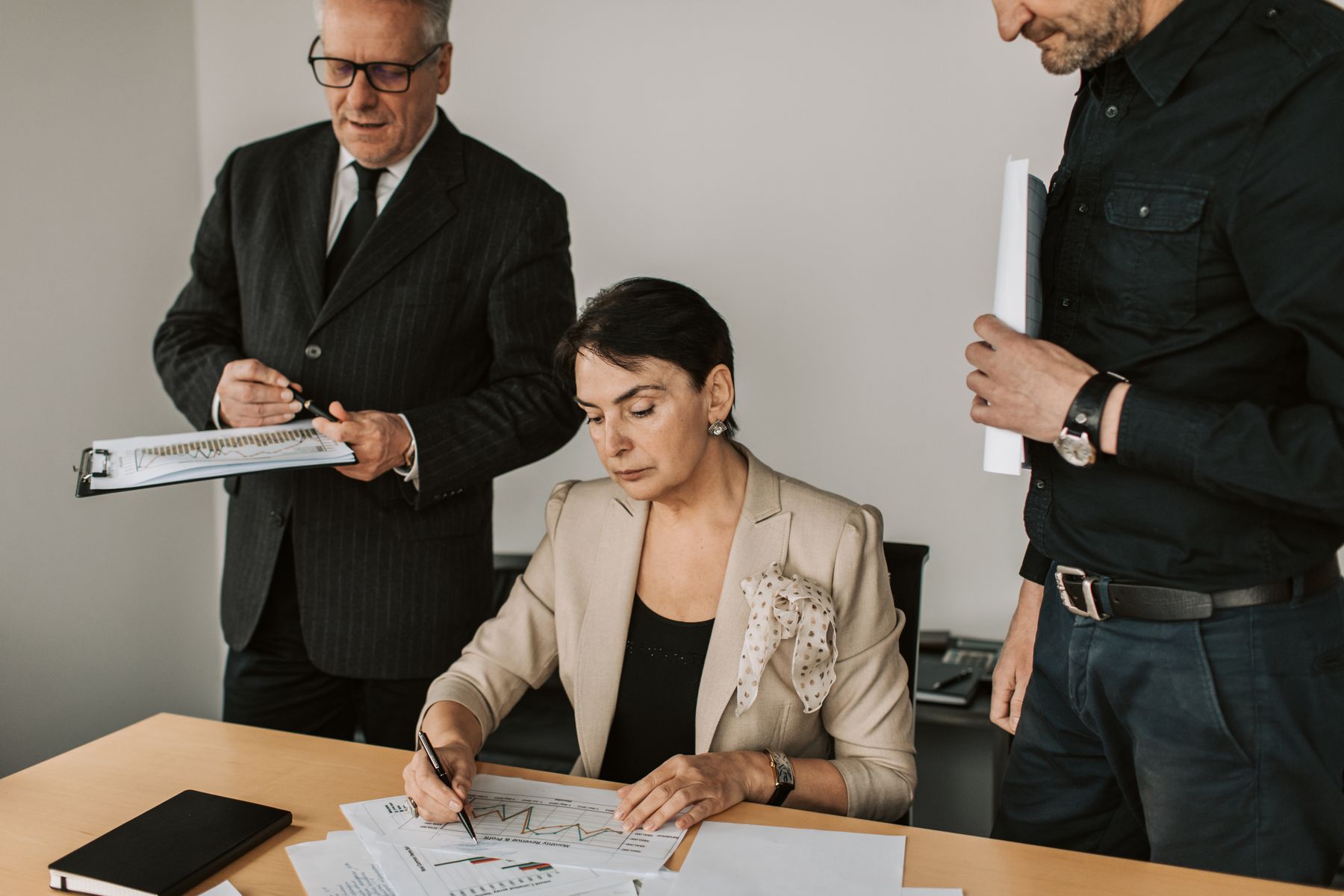 Profissionais analisam gráficos e documentos numa reunião de trabalho
